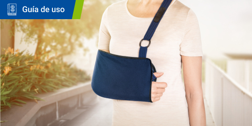 Mujer sonriente que lleva un cabestrillo para el hombro de Actimove. Se lee el texto “Guía de uso” en un recuadro. Mujer sonriente que lleva un cabestrillo para el hombro de Actimove. Se lee el texto “Guía de uso” en un recuadro.